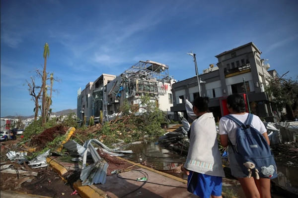 Người dân đứng nhìn những thiệt hại do siêu bão Otis gây ra ở thành phố Acapulco (Mexico). Ảnh: Henry Romero/ Reuters.