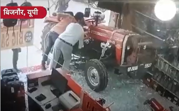 Vài người cùng cố gắng ngăn chặn chiếc máy kéo. Ảnh: Twitter.