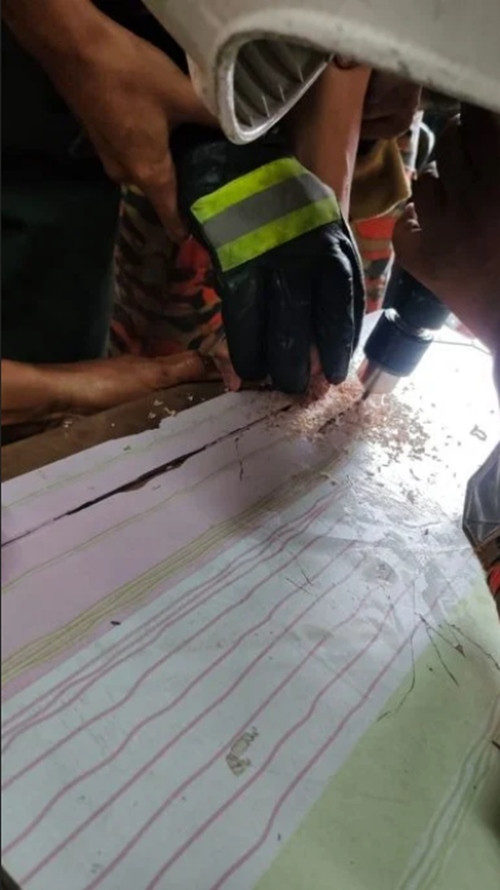 Đội cứu hỏa dùng dụng cụ chuyên dụng để giúp nam sinh. Ảnh: Sin Chew Daily. Đội cứu hỏa dùng dụng cụ chuyên dụng để giúp nam sinh. Ảnh: Sin Chew Daily.