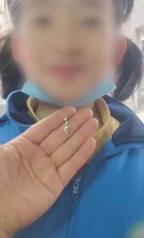 Bé gái được bạn trai cùng lớp tặng quà là một sợi dây chuyền. Ảnh: Weibo.