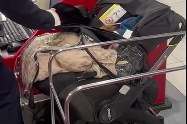 Em nhỏ nằm trong xe đẩy bị bố mẹ bỏ lại ở quầy check-in. Ảnh: NY Post/ Channel 12. Em nhỏ nằm trong xe đẩy bị bố mẹ bỏ lại ở quầy check-in. Ảnh: NY Post/ Channel 12.
