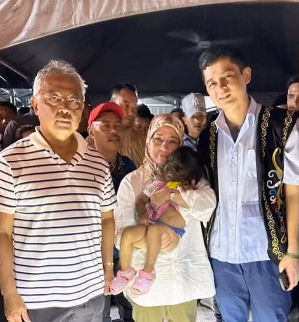 Vua Malaysia (trái) và Hoàng hậu (giữa) đang bế bé gái Missclyen Roland. Ảnh: ISTANA NEGARA.