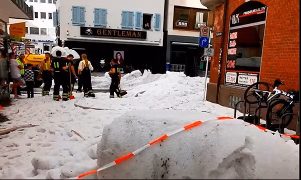 Nhiều người đang cố dọn đá trên các con đường sau trận mưa đá kỳ lạ ở Reutlingen (Đức). Ảnh: Timo Mendritzki/ Reuters.