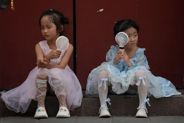 Các em nhỏ ở Bắc Kinh (Trung Quốc) dùng quạt điện cầm tay cho đỡ nóng. Ảnh: Andy Wong/ AP. Các em nhỏ ở Bắc Kinh (Trung Quốc) dùng quạt điện cầm tay cho đỡ nóng. Ảnh: Andy Wong/ AP.