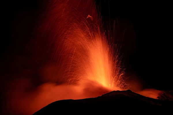 Núi lửa Etna làm sáng rực bầu trời đêm khi nhìn từ thành phố Catania (Ý). Ảnh: Etna Walk/ Marco Restivo/ Handout via REUTERS.
