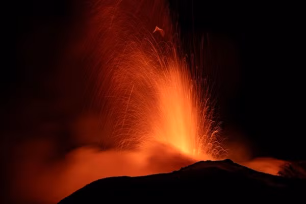 Núi lửa Etna làm sáng rực bầu trời đêm khi nhìn từ thành phố Catania (Ý). Ảnh: Etna Walk/ Marco Restivo/ Handout via REUTERS.