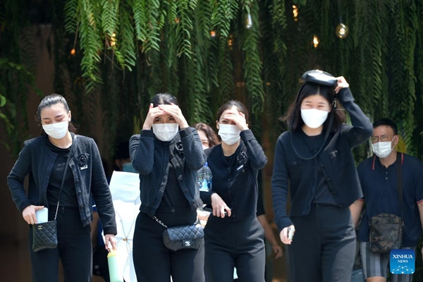 Người đi bộ cố che chắn dưới nắng nóng ở Bangkok (Thái Lan). Ảnh: Rachen Sageamsak/ Xinhua.