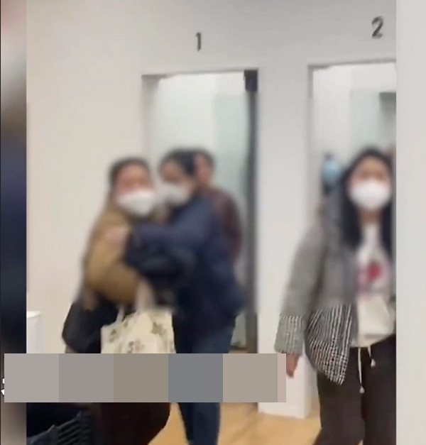 Nhân viên cửa hàng Uniqlo (áo khoác xanh tím than) đang cố bảo một bà mẹ hãy bình tĩnh. Ảnh: Weibo. Nhân viên cửa hàng Uniqlo (áo khoác xanh tím than) đang cố bảo một bà mẹ hãy bình tĩnh. Ảnh: Weibo.