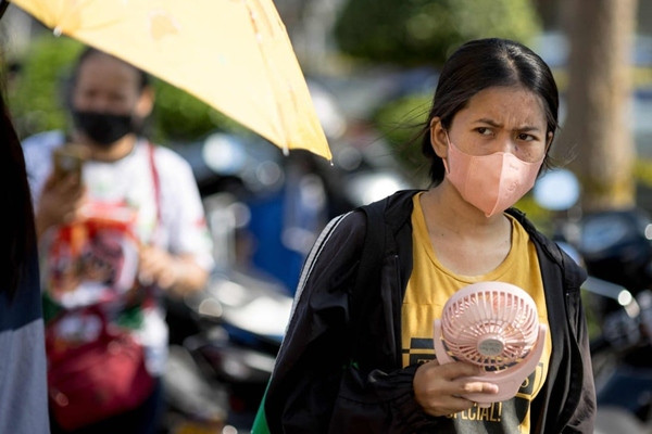 Một phụ nữ mang theo quạt ra phố ở Thái Lan. Ảnh: AFP. Một phụ nữ mang theo quạt ra phố ở Thái Lan. Ảnh: AFP.