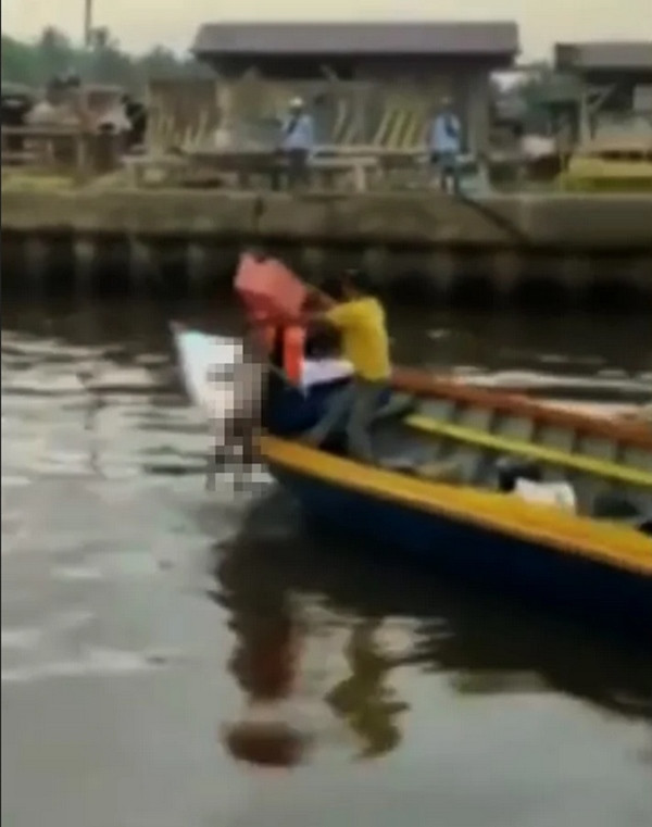 Sau khi cá sấu bơi đi, gia đình đã đưa thi thể cậu bé vào bờ. Ảnh: Gulf Today.