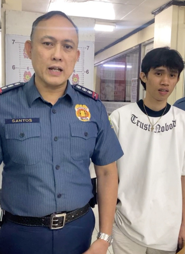 Anh Mark (bên phải) đi báo cảnh sát về việc mình bị giật điện thoại. Ảnh: Hayme Santoast.