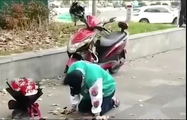 Chàng trai cứ việc quỳ cùng bó hoa, cô gái đã không xuất hiện. Ảnh: Baidu.