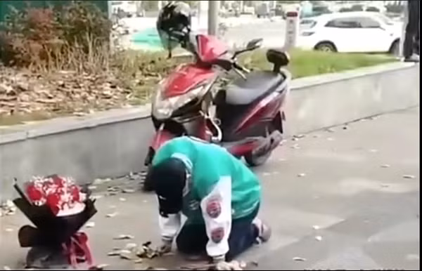 Chàng trai cứ việc quỳ cùng bó hoa, cô gái đã không xuất hiện. Ảnh: Baidu.
