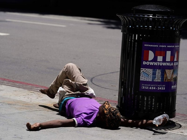 Miền Nam nước Mỹ đang trải qua đợt nóng căng thẳng trong những tuần gần đây. Trong ảnh là một người mệt mỏi nằm ngay trên vỉa hè, tay cầm chai nước, ở Los Angeles vào ngày 2/7. Ảnh: AP.