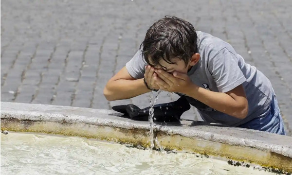 Một em nhỏ vớt nước ở bồn phun nước lên mặt cho đỡ nóng tại Rome (Ý). Ảnh: Anadolu Agency/ Getty Images. Một em nhỏ vớt nước ở bồn phun nước lên mặt cho đỡ nóng tại Rome (Ý). Ảnh: Anadolu Agency/ Getty Images.