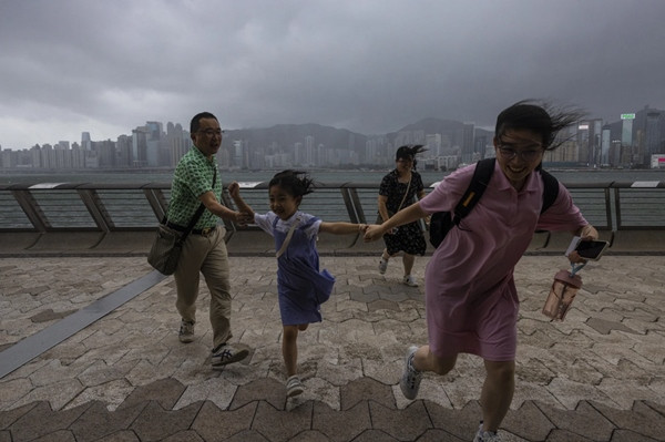 Du khách chạy trong gió to do bão ở Hong Kong (Trung Quốc) vào ngày 17/7. Ảnh: Louise Delmotte/ AP.