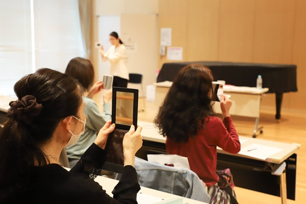 Học viên đang cầm những chiếc gương để tập cười trong một lớp học ở Yokohama. Ảnh: LOUISE CLAIRE WAGNER. Học viên đang cầm những chiếc gương để tập cười trong một lớp học ở Yokohama. Ảnh: LOUISE CLAIRE WAGNER.