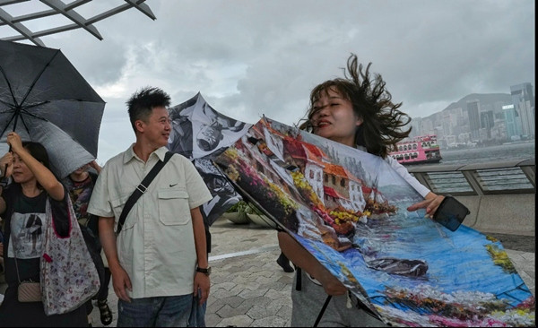 Người dân Hong Kong (Trung Quốc) trong những cơn gió mạnh do bão Talim. Ảnh: Elson Li. Người dân Hong Kong (Trung Quốc) trong những cơn gió mạnh do bão Talim. Ảnh: Elson Li.