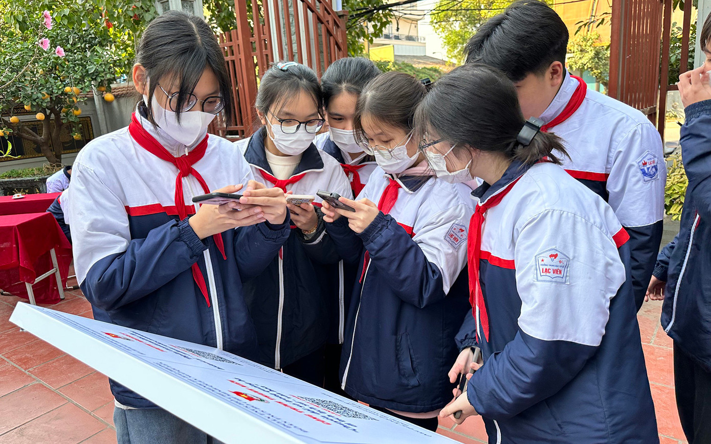 Nhiều đoàn viên, thanh thiếu nhi sử dụng điện thoại quét mã QR tìm hiểu các thông tin về di tích lịch sử - văn hóa.