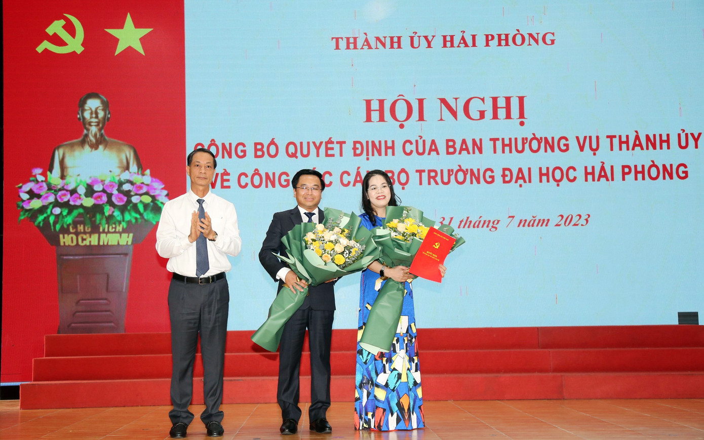 Ông Đỗ Mạnh Hiến - Phó Bí thư Thường trực Thành ủy trao quyết định, tặng hoa chúc mừng tân Bí thư Đảng ủy, tân Hiệu trưởng Đại học Hải Phòng.