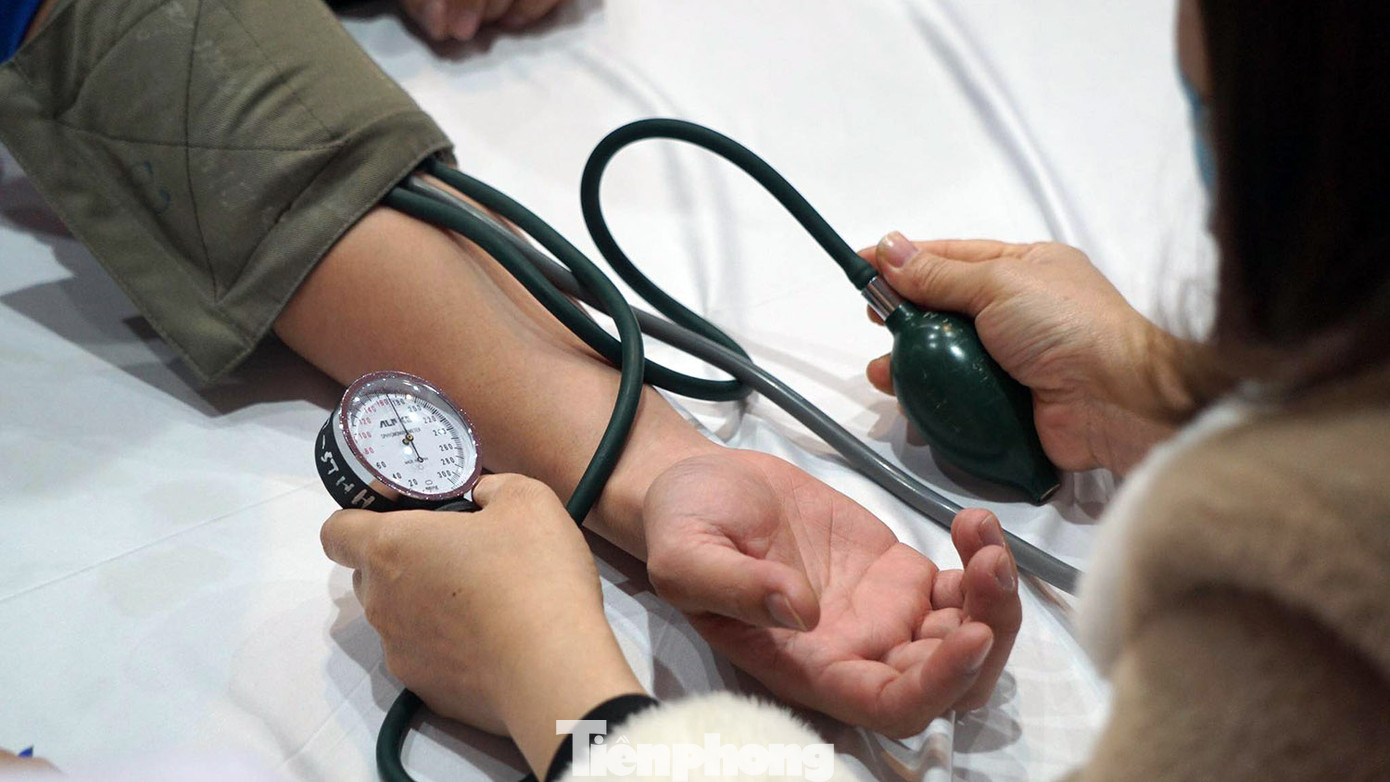 Các tình nguyện viên được nhân viên y tế hướng dẫn đăng ký, kiểm tra sức khỏe.