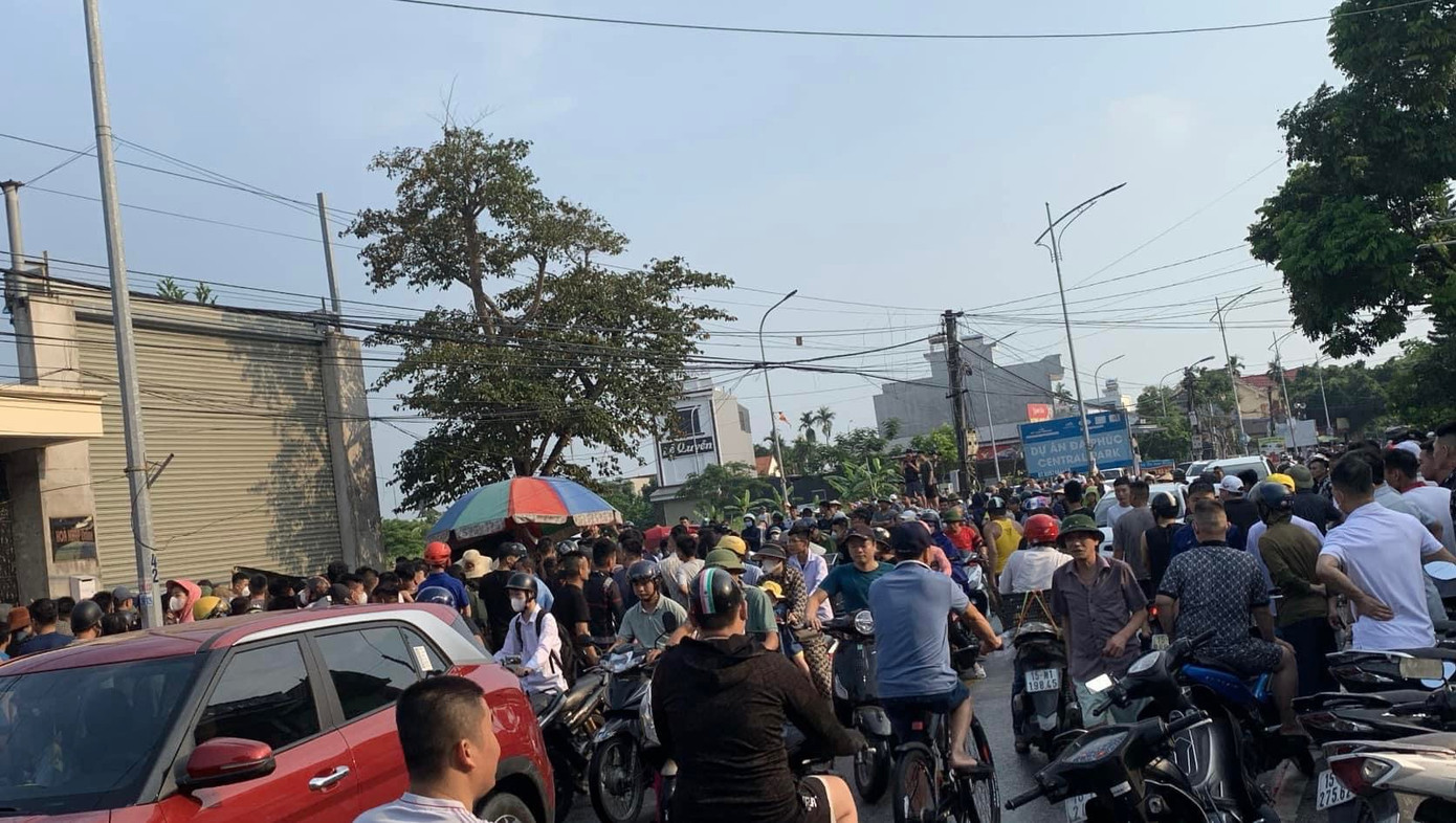 Người dân theo dõi lực lượng chức năng khám nghiệm hiện trường vụ thi thể phụ nữ trong bao tải trên vỉa hè ở Hải Phòng.