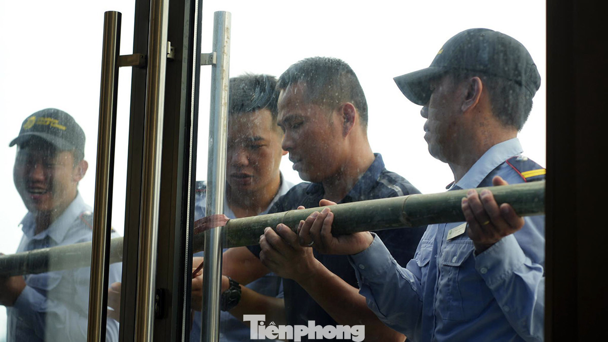 Nhân viên Sân golf Đồi Rồng chằng nẹp cửa kính chống bão. Ảnh: Trọng Quân Nhân viên Sân golf Đồi Rồng chằng nẹp cửa kính chống bão. Ảnh: Trọng Quân