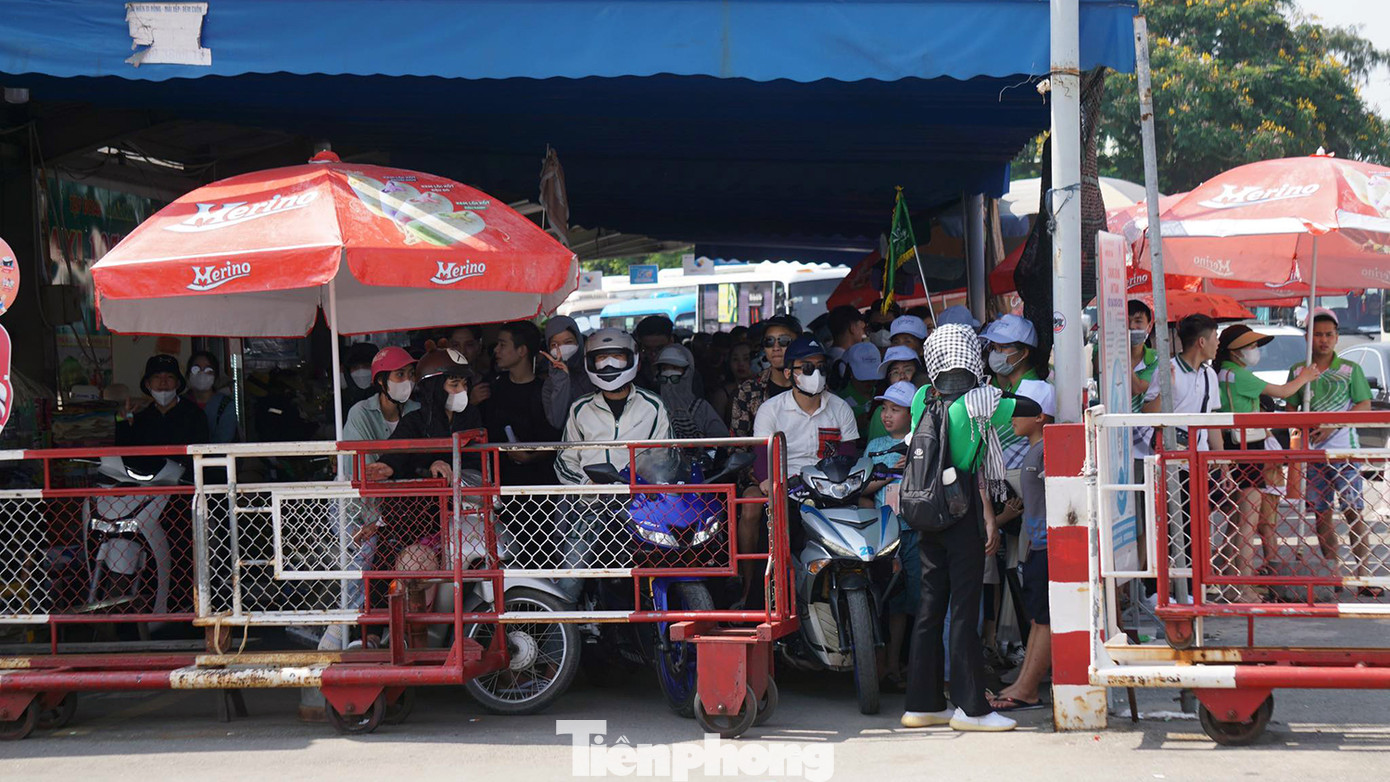 Tại khu vực chờ phà, người điều khiển xe máy và khách đi bộ xếp hàng chật kín chờ tới lượt.