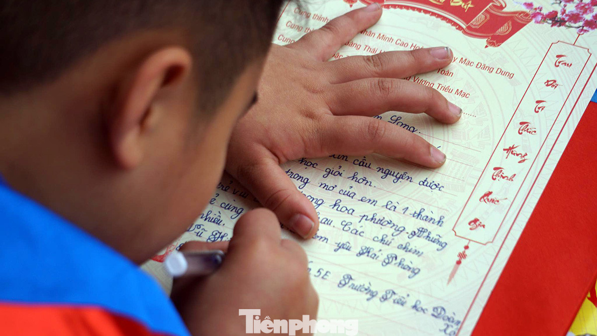 Các em học sinh nắn nót viết ước mơ, nguyện vọng của mình lên giấy trong ngày hội khai bút. Các em học sinh nắn nót viết ước mơ, nguyện vọng của mình lên giấy trong ngày hội khai bút.