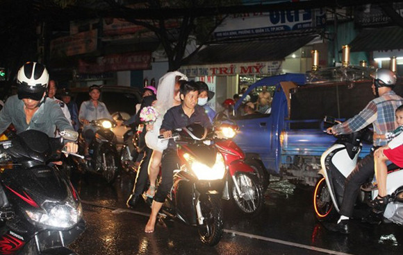 Xe chở cô dâu và chú rể bị chết máy trên đường Hòa Bình buộc cô dâu và chú rể phải lội nước đen kịt, bốc mùi để đón xe ôm đến nơi tổ chức lễ thành hôn