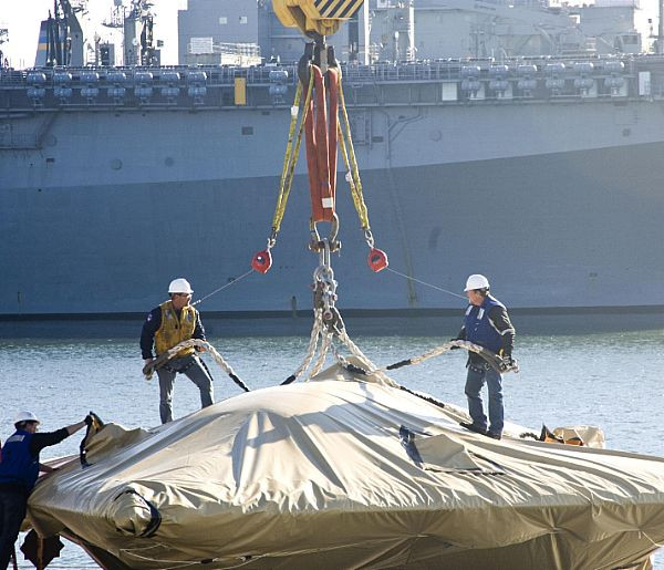 X-47B được bọc vải để chuẩn bị cẩu lên tàu sân bay USS Harry S. Truman