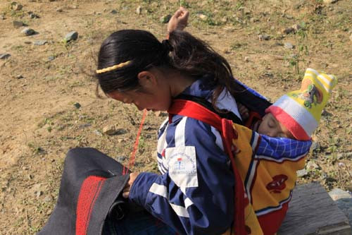 Em bé ngủ ngon trên lưng người thân bên triền núi Cổng Trời