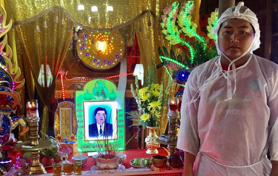 Anh Huỳnh Tấn Thành (con ông Hải) đeo khăn tang trước linh cửu người cha. Ảnh Tân An