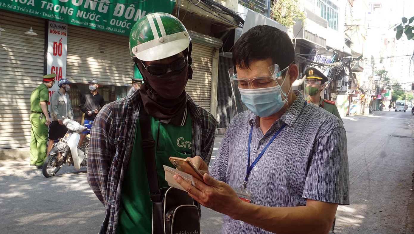 Cán bộ tại chốt giải thích cho lái xe việc ra ngoài không vì mục đích thiết yếu sẽ bị phạt.