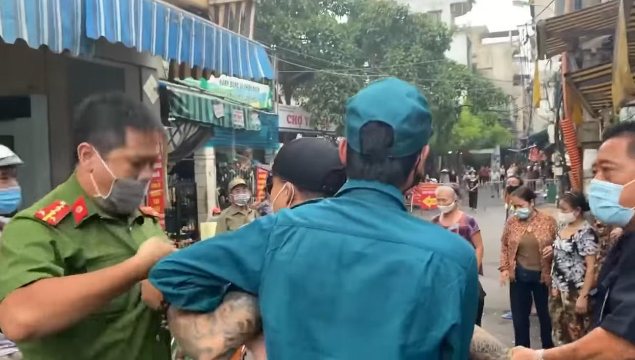 Người đàn ông túm áo, giằng co với công an tại chốt.