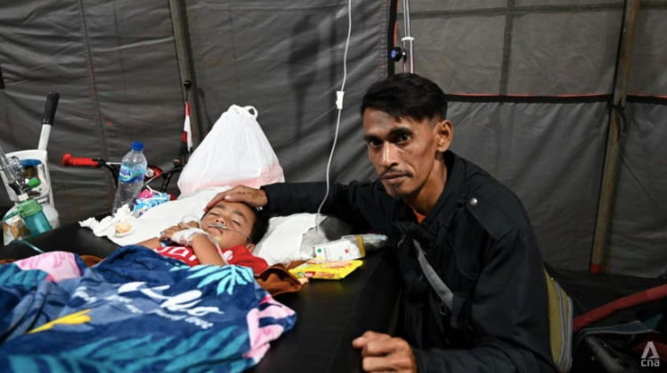 Eka ngồi bên cậu con trai 5 tuổi. (Ảnh: CNA)