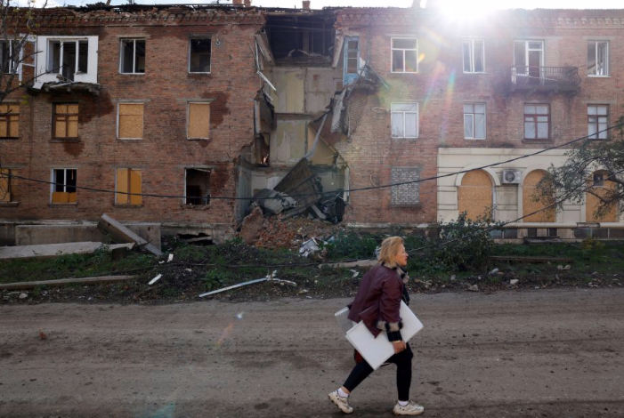 Một phụ nữ đi qua toà nhà bị trúng tên lửa ở Bakhmut, Ukraine. (Ảnh: Reuters) Một phụ nữ đi qua toà nhà bị trúng tên lửa ở Bakhmut, Ukraine. (Ảnh: Reuters)