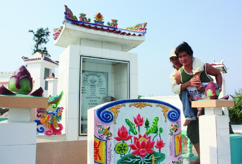 Hai đứa con bên mộ gió lão ngư Nguyễn Đảng. Hai đứa con bên mộ gió lão ngư Nguyễn Đảng