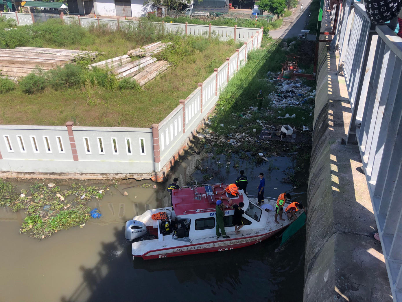 Lực lượng chức năng tiến hành trục vớt thi thể ông V. lên bờ. Ảnh: Nguyễn Hoàng Lực lượng chức năng tiến hành trục vớt thi thể ông V. lên bờ. Ảnh: Nguyễn Hoàng