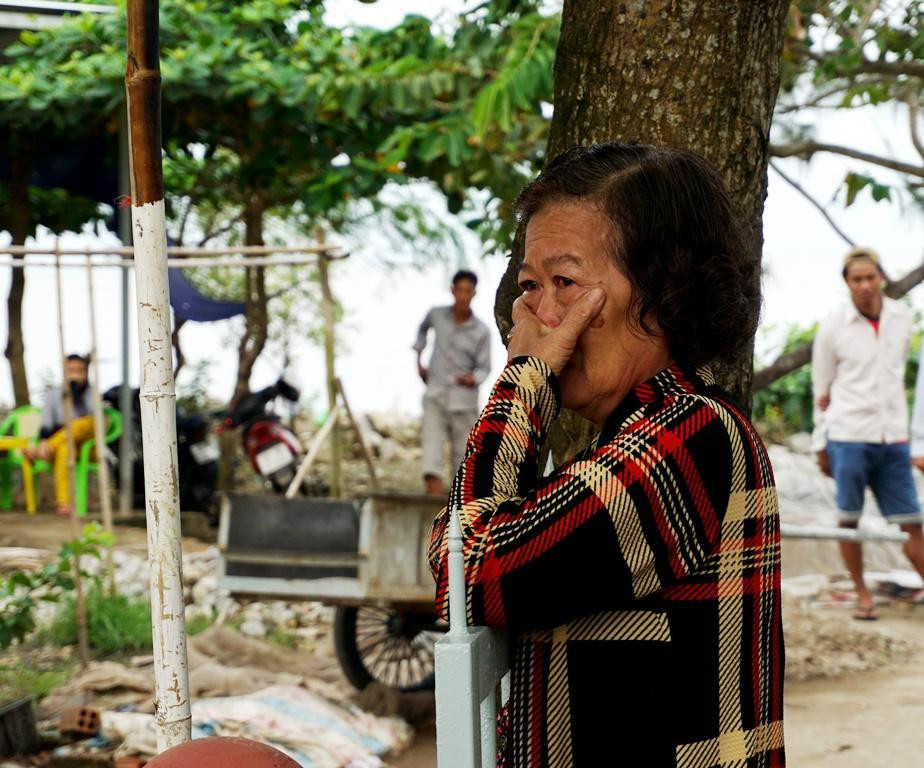 Một người phụ nữ ở xã Khánh Hội bùi ngùi trước đài tưởng niệm 25 năm cơn bão Linda.