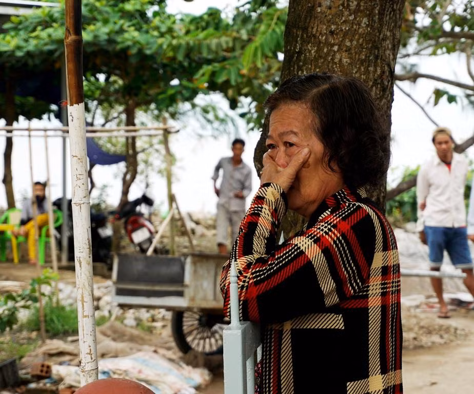 Một người phụ nữ ở xã Khánh Hội bùi ngùi trước đài tưởng niệm 25 năm cơn bão Linda.