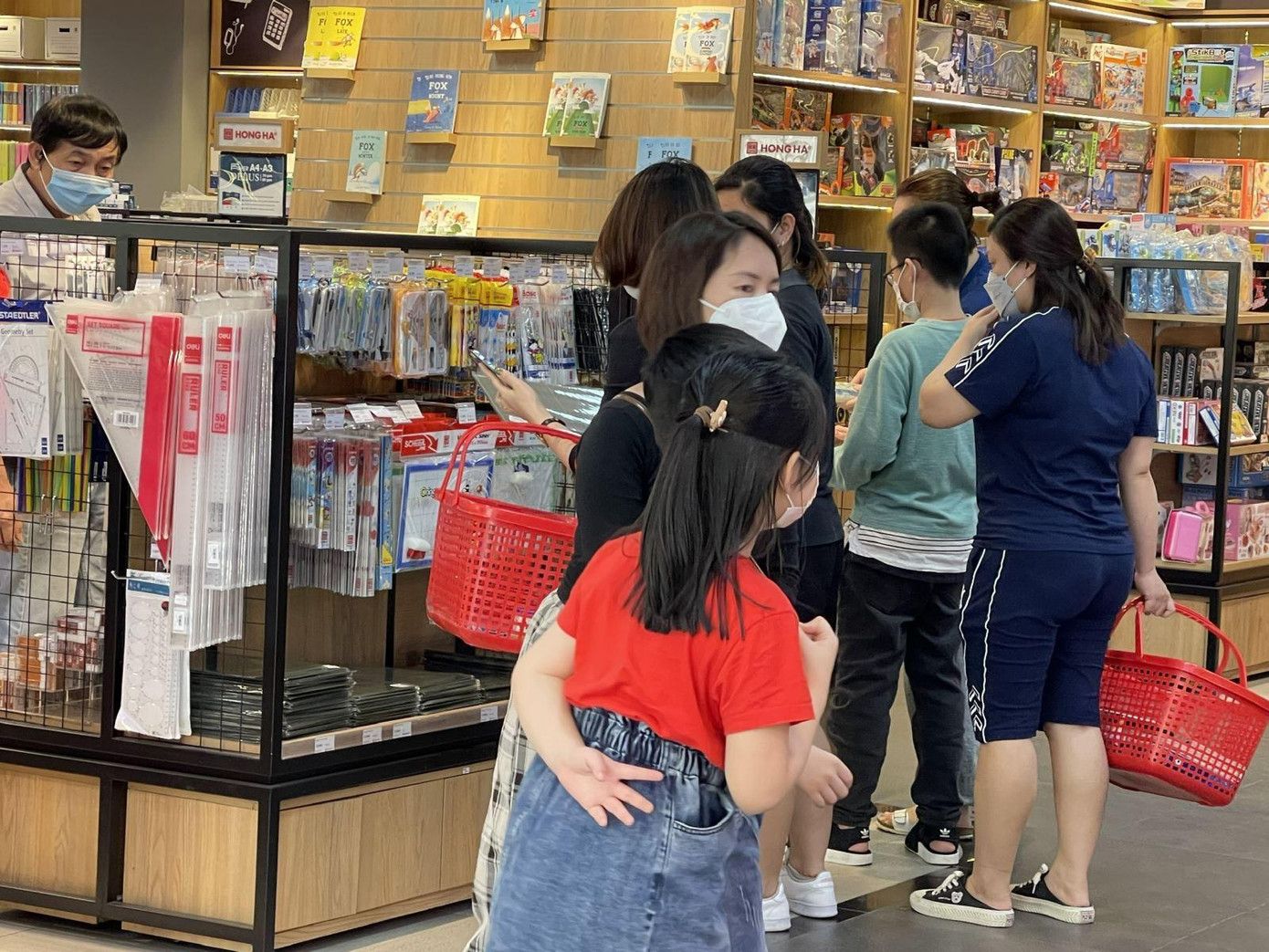 Nhiều em nhỏ được đi cùng cha mẹ để sắm đồ dùng học tập.