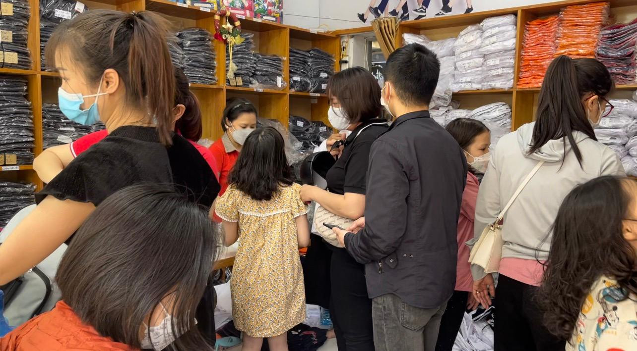 Rất đông phụ huynh chở con tới cửa hàng bán đồng phục học sinh để mua quần áo chuẩn bị tới trường.