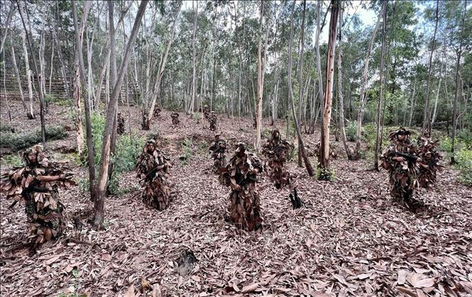 Chiến sĩ CSCĐ chống khủng bố thực hiện bài tập nguỵ trang dưới lớp lá khô tiếp cận đối tượng một khoảng cách gần nhất mà không bị phát hiện.