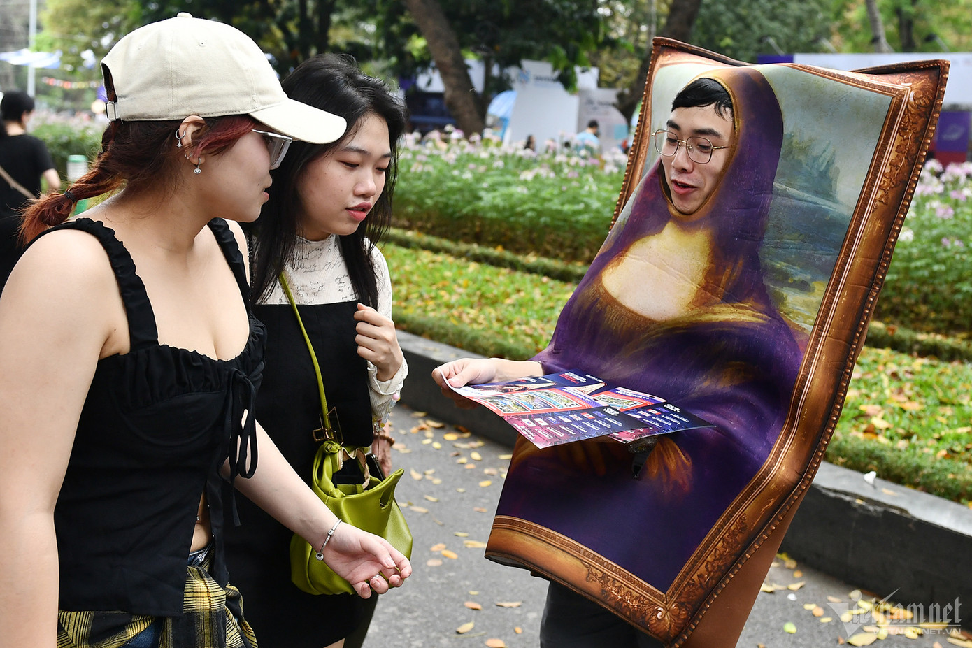 Còn anh Vinh, nhân viên chuyên tư vấn và làm visa du lịch châu Âu chui vào trong một bức tranh hình nàng Mona Lisa để phát tờ rơi cho khách quảng bá du lịch Pháp.