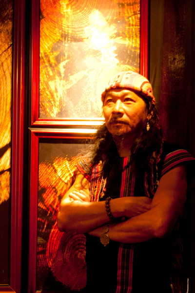 Nghệ sĩ MPK cạnh một tác phẩm vân gỗ