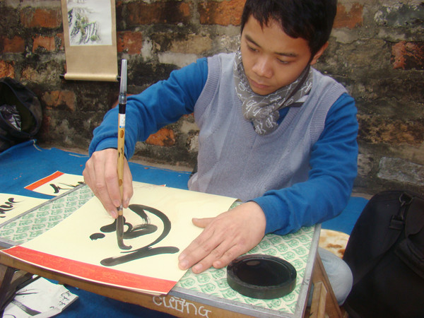 Một nhà thư pháp trẻ tại phố ông đồ năm nay đang cho chữ
