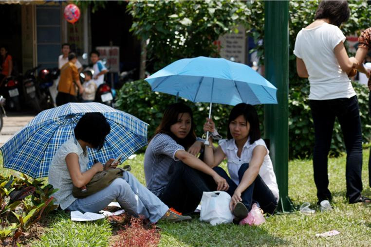 Trời nắng nóng đã khiến hàng trăm khách tham quan dùng bãi cỏ giữa đường Văn Cao làm chỗ ngồi nghỉ chân!