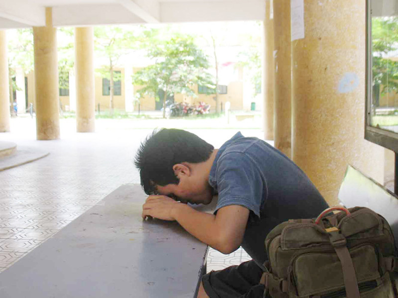 Kiếm được chỗ mát ở khu hiệu bộ ĐH Văn hóa Hà Nội, một thí sinh tranh thủ ngủ ngon lành. Ảnh: Quý Hiên