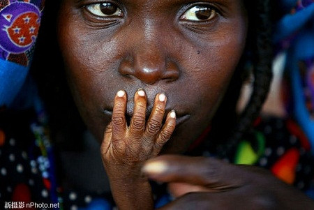 2005: Những ngón tay của em bé 1 tuổi suy dinh dưỡng Alassa Galisou trên môi bà mẹ Fatou Ousseini tại một trung tâm cứu trợ lương thực khẩn cấp ở Nigeria